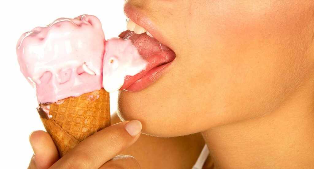 Девушка лижет мороженое 